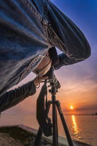 Close-up of sailboat in sea against sky during sunset