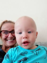 Portrait of cute baby boy with grandmother at home