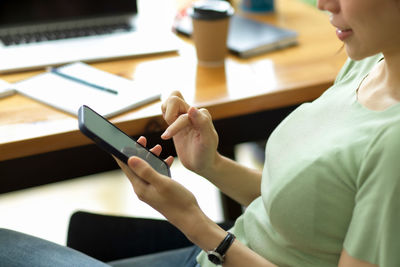 Midsection of woman using mobile phone