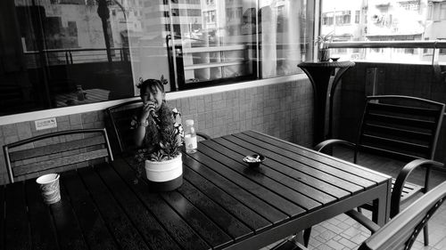 Portrait of girl eating food while sitting at table in restaurant