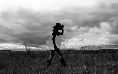 Woman standing on field against sky