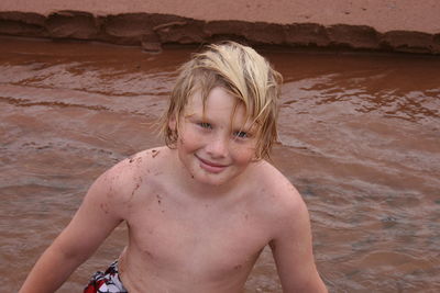 Portrait of smiling shirtless boy in river 