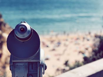 Close-up of coin-operated binoculars against sea