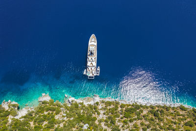 Low angle view of people in sea against clear blue sky