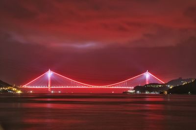 Suspension bridge over river at night