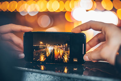 Midsection of man holding mobile phone