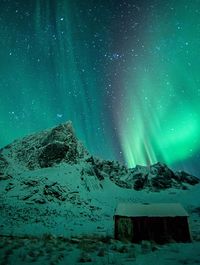 Low angle view of snowcapped mountain against star field