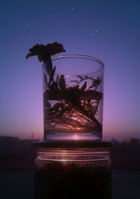 Close-up of wine glass on table against clear sky at night