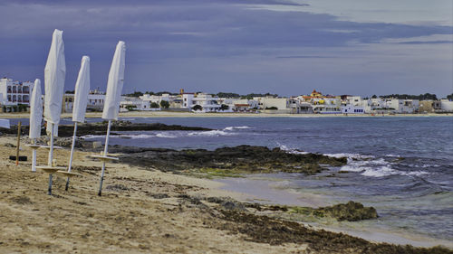 Buildings by sea against sky in city