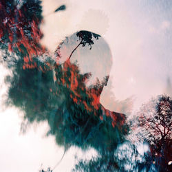 Double exposure of man and trees