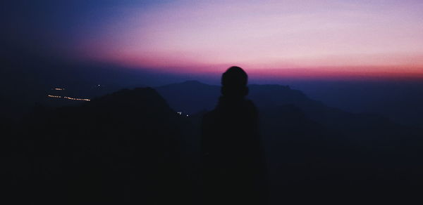 Silhouette people standing on mountain against sky during sunset