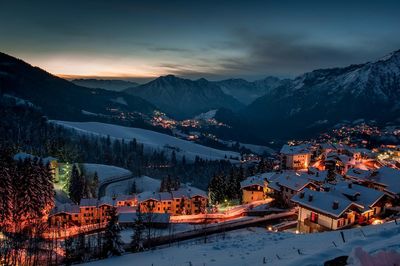 Illuminated buildings against sky during winter at night