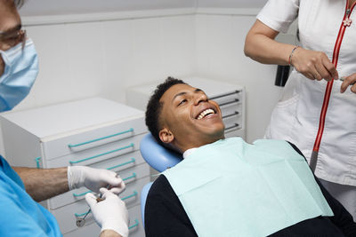 Smiling patient amidst doctors in clinic