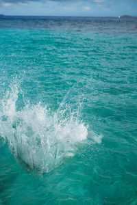 Huge splashing water in the sea from people falling into water, abstract art picture for background.