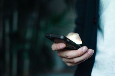 Midsection of man using mobile phone