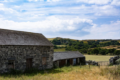 Old house on field against sky