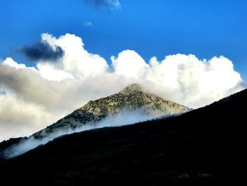 Scenic view of mountains against cloudy sky