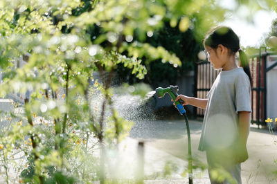 Girl spraying water on plants 