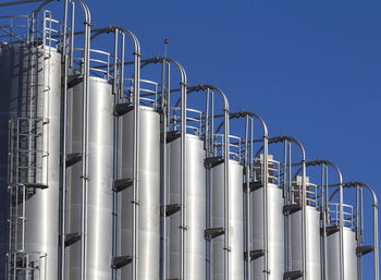 Low angle view of industry against blue sky