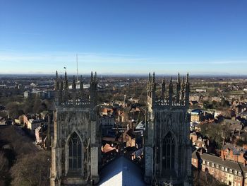 High angle view of york minster amidst buildings in city against blue sky