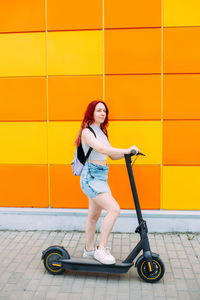 Portrait of young woman walking on footpath