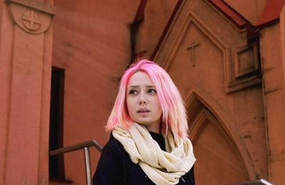 Low angle view of young woman by church