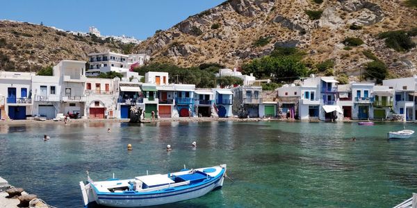 Boats moored on sea by buildings in town