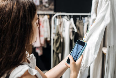 Ecommerce and sell online. woman taking picture of clothes in the shop. second hand, selling used