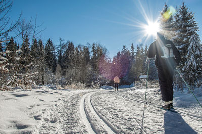 Rear view of man walking on snow covered landscape