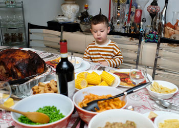 Curious little boy sitting at thanksgiving table