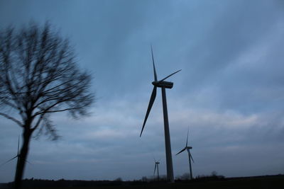 Low angle view of windmill on field against sky