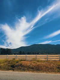 Road by field against sky