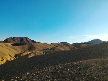 Scenic view of mountains against clear blue sky