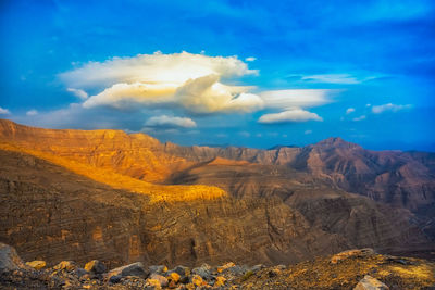 Scenic view of mountain range against cloudy sky