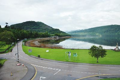 Scenic view of road by mountains against sky