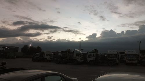 Cars on road against sky during sunset