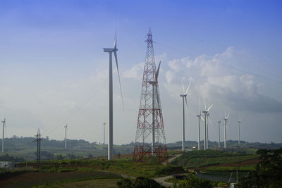 Electricity pylon on field against sky