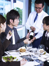 Colleagues with drinks at restaurant during meeting