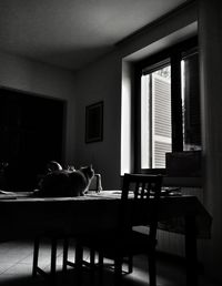 Rear view of woman sitting on table at home