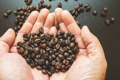 Close-up of hand holding coffee beans