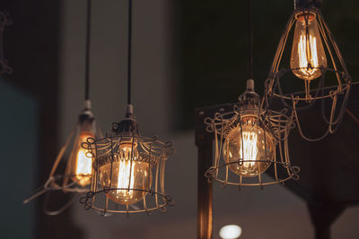 Close-up of illuminated pendant lights hanging in store