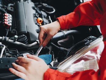 Midsection of mechanic repairing car in workshop