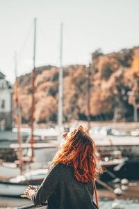Rear view of woman standing on boat against sky
