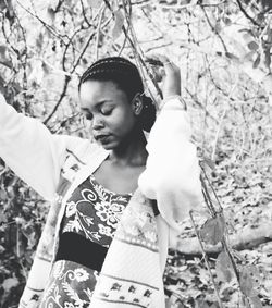 Close-up of young woman holding tree