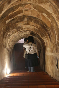 Rear view of woman standing in corridor