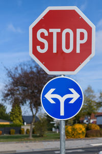 Close-up of road sign against blue sky