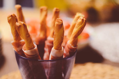 Close-up of breadsticks in container on table