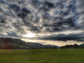 Scenic view of field against cloudy sky