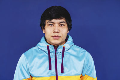 Portrait of young man against blue background