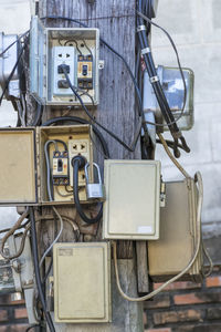 Close-up of old telephone booth against wall